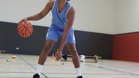 Porträt-Eines-Afroamerikanischen-Männlichen-Basketballspielers,-Der-In-Zeitlupe-Auf-Dem-Hallenplatz-Spielt