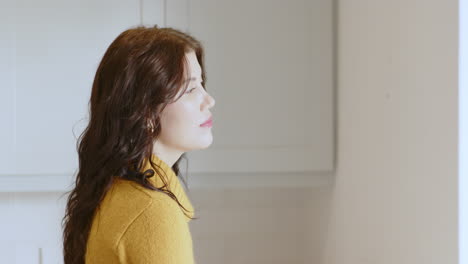 woman in yellow sweater relaxing at home, enjoying peaceful moment, copy space