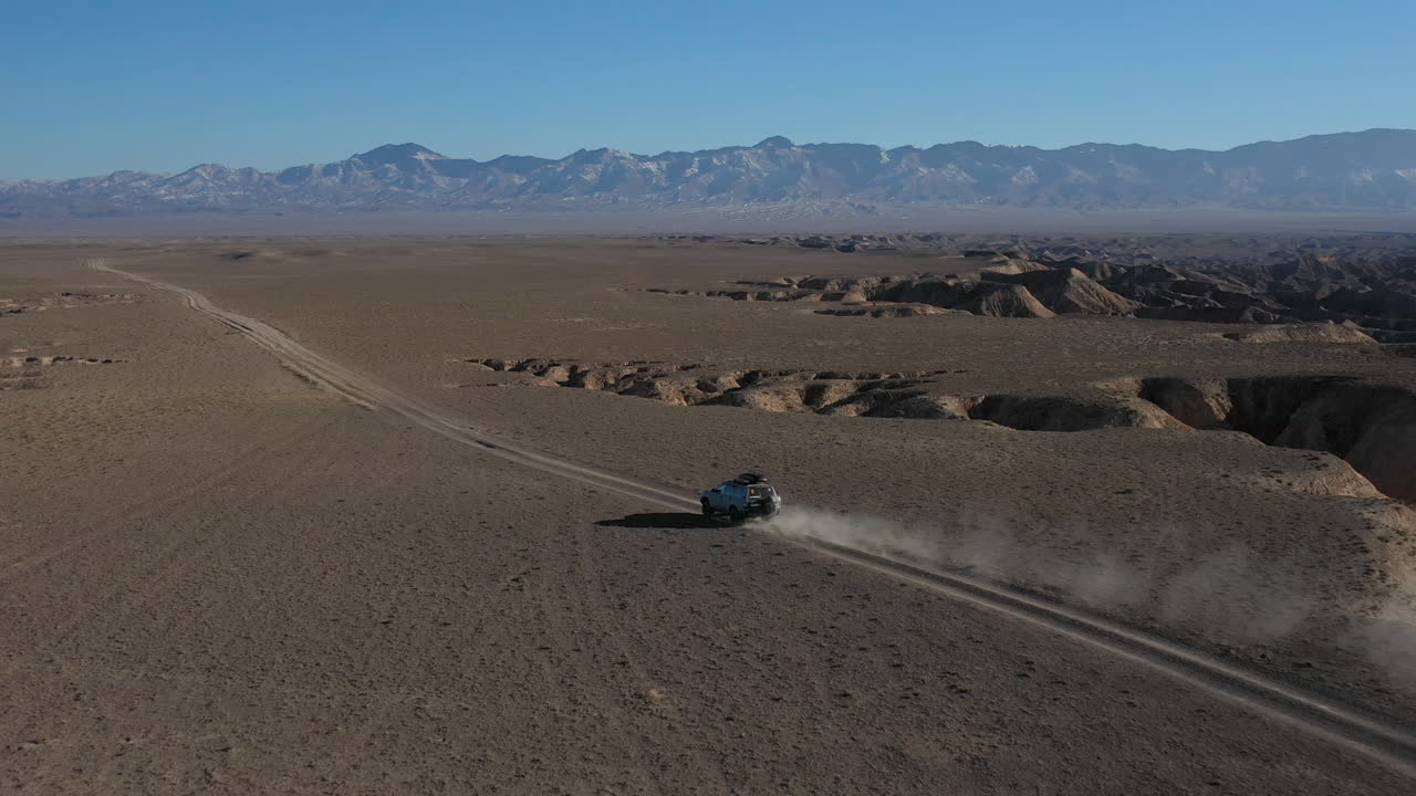 카자흐스탄의 차린 협곡을 여행하는 자동차의 영화적 추적 드론 샷