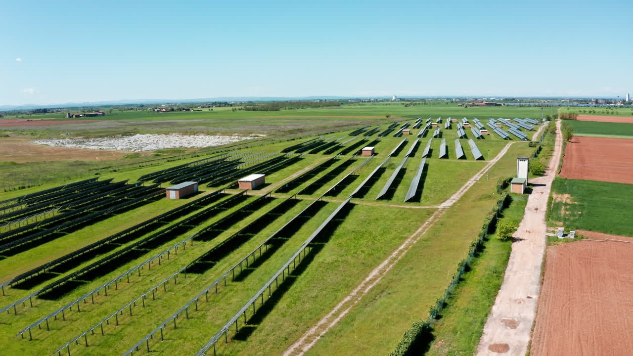 paneles solares en un campo verde en un día soleado con un cielo azul claro, vista aérea