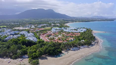 Idyllic-sandy-beach-with-turquoise-Caribbean-sea,-backed-by-resorts