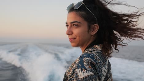 Profile-view-of-a-woman-with-the-wind-in-her-hair-on-a-boat-ride,-close-up-slow-motion