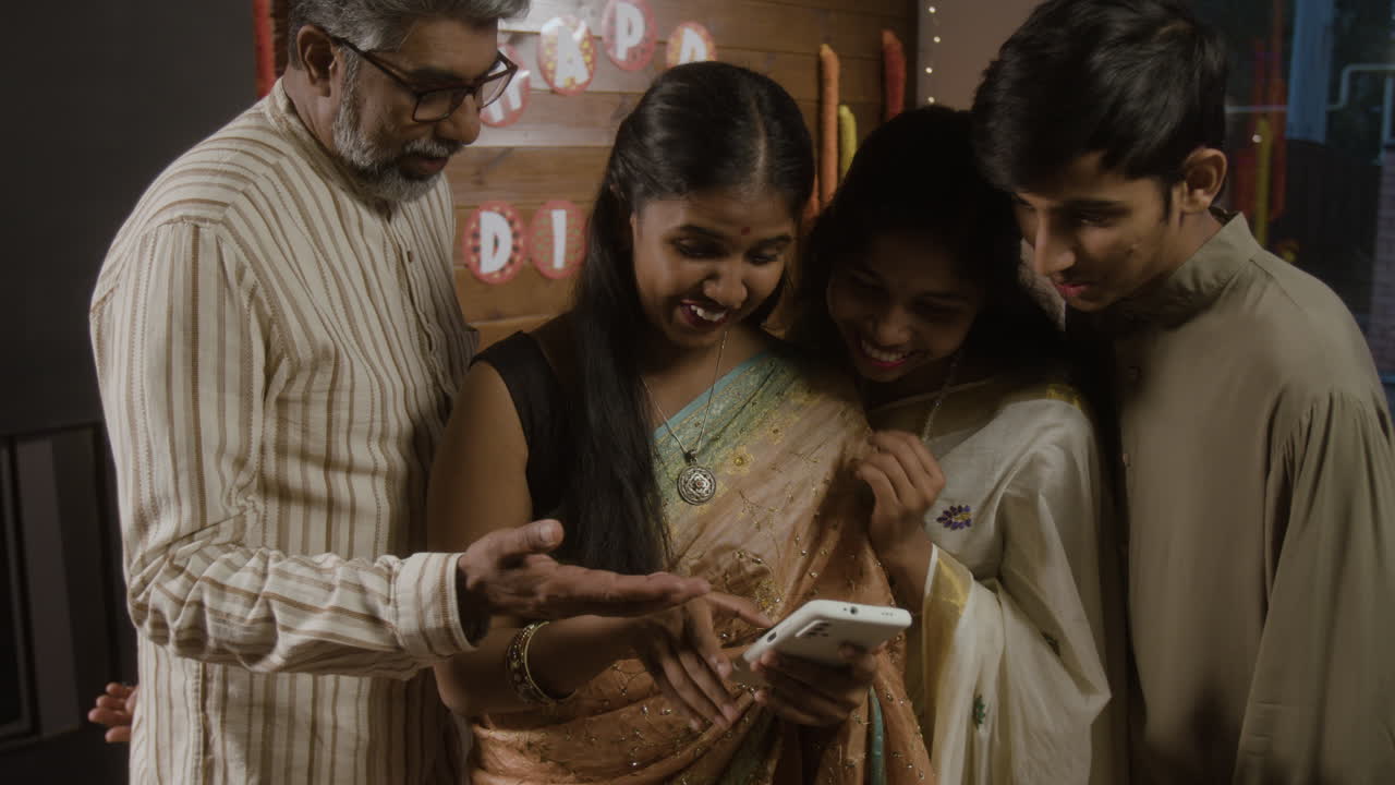Famiglia che festeggia Diwali e usa uno smartphone