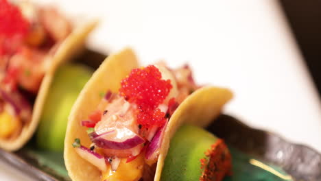 chef putting red caviars on top of delicious sushi tacos