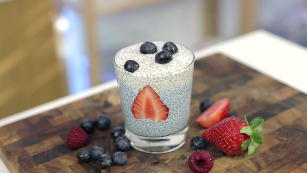 decorare la parte superiore del budino di chia sano in un bicchiere, bellissimo budino di chia spirulina blu