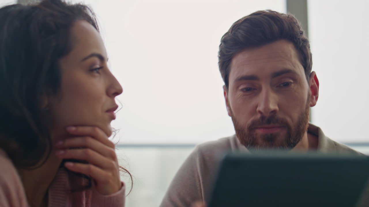 esposa sonriente mostrando la pantalla de la tableta al marido relajado en un primer plano plano panorámico