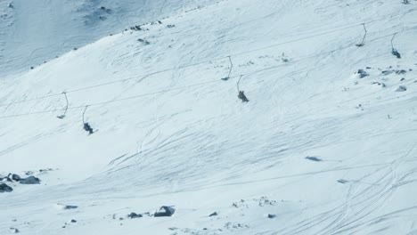 Telesillas-De-Esquí-Alpino-Transportan-A-Los-Esquiadores-A-Lo-Largo-De-La-Pendiente-Nevada
