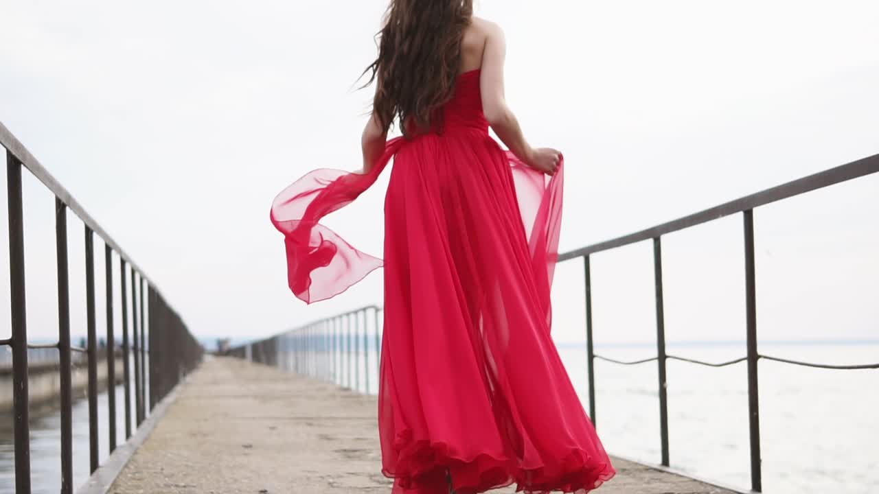 Woman in Red Dress Running on a Pier