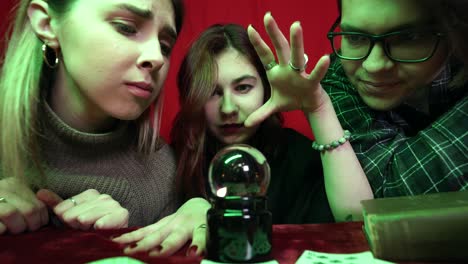 friends gather around a crystal ball for a fortune-telling session