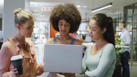 Diverse-female-business-colleagues-talking-and-using-laptop