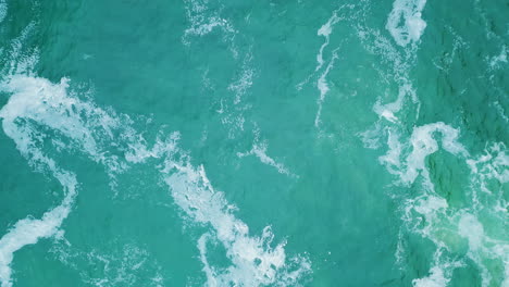 top turquoise water waving in super slow motion. aerial ocean waves splashing.