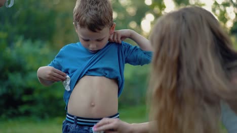 nice little boy raises t-shirt bottom