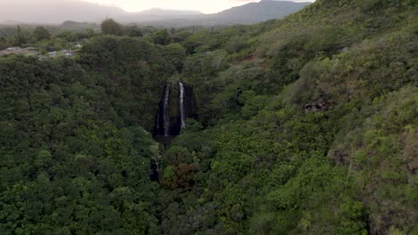 Dramatic-aerial-footage-of-famous-Wailua-Falls-durig-sunset-with-white-birds-flying-above