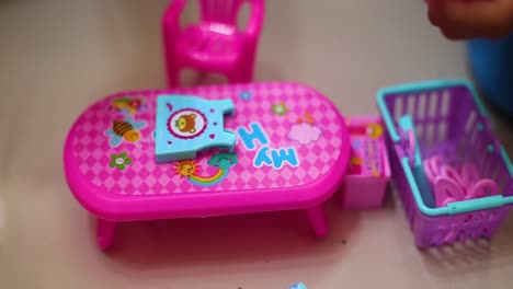 Ein-Hübsches-Kleines-Mädchen-Spielt-Eine-Hausfrau-Und-Bügelt-Kinderkleidung-Mit-Einem-Spielzeugbügeleisen
