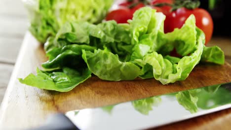 verduras y cuchillo de cocina en una mesa de madera