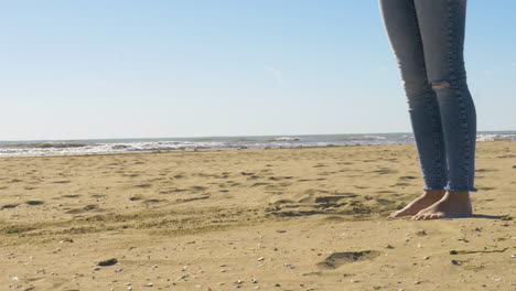 Mittlere-Aufnahme-Weiblicher-Beine,-Die-Am-Strand-Sand-Treten