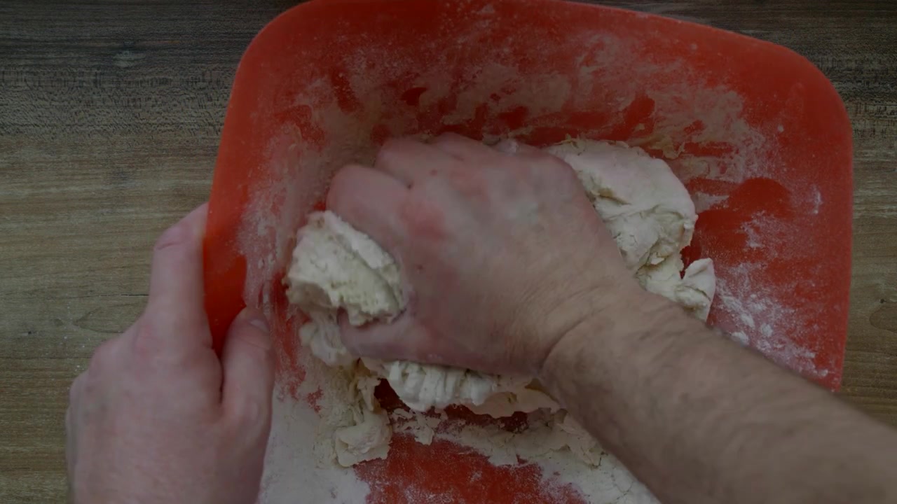 Impastare la pasta in una ciotola mentre si preparano prodotti da forno fatti in casa