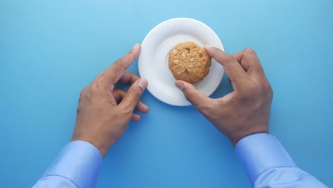persona sosteniendo una galleta en un plato