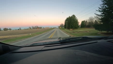 point of view - driving on a rural county road through a small town and approaching a strop sign