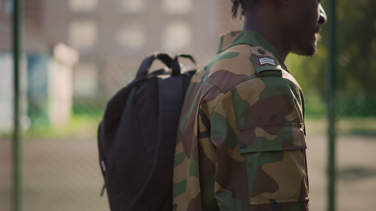 Soldier Walking Onward, Uniformed Individual Traveling Through Field With Determination And Focus, Skilled Soldier In Camouflage Attire Strides Purposefully Beside Boundary Under Clear Sky