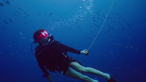 scuba diver deploying a surface marker buoy (smb) underwater