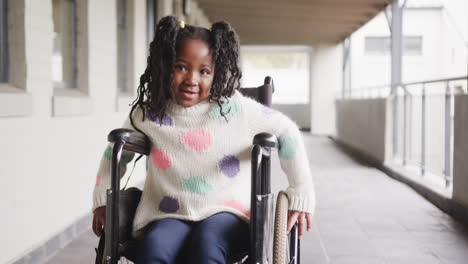 smiling girl in wheelchair enjoying school hallway, wearing colorful sweater