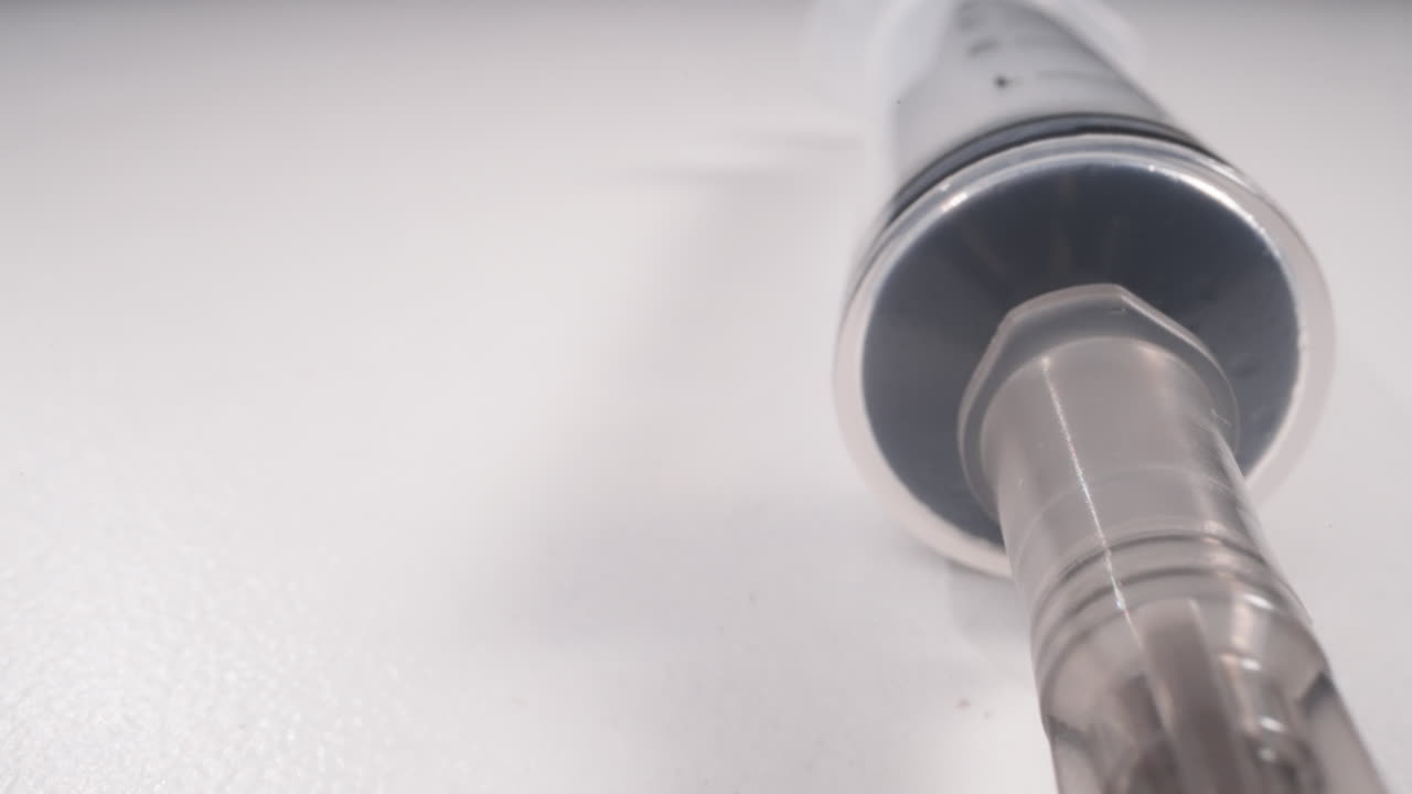 nueva jeringa con aguja abierta en macro de fondo blanco