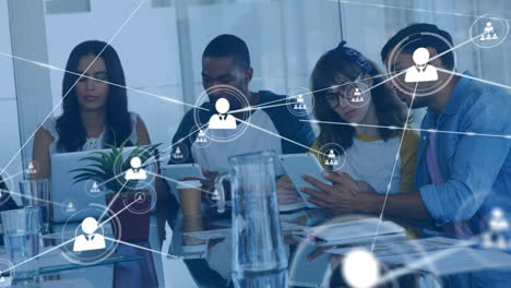 animation of network of profile icons against team of diverse colleagues discussing at office