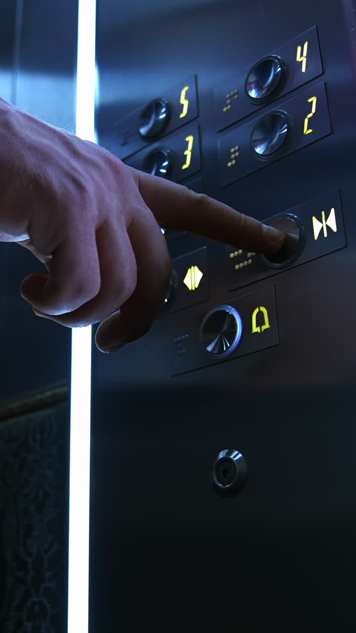 Businessman in lift. Male's hand pressing button to start moving inside the elevator. Man touches elevator button in hotel or high-rise building. Vertical video