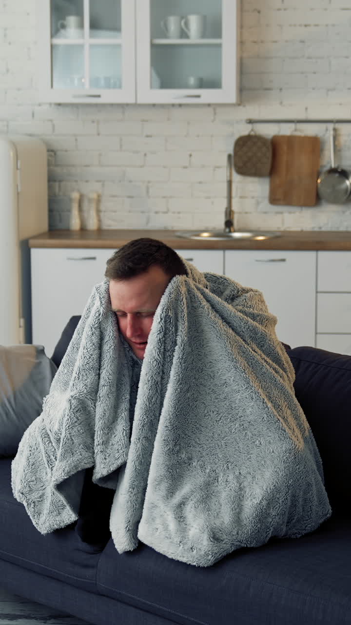 Sick young man suffering from flu at home. Pandemic. Quarantine concept. Vertical video
