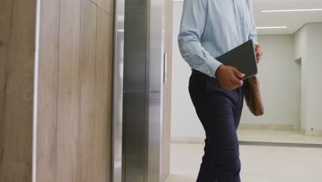 Diverse-business-people-taking-elevator-at-office,-slow-motion