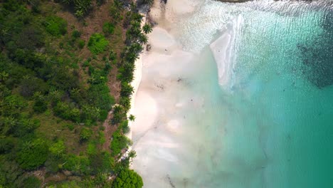 crystal clear turquoise water gently washing pristine white sand beach next to tropical vegetation in idyllic paradise koh chang thailand. beautiful aerial view flight drone top down above view