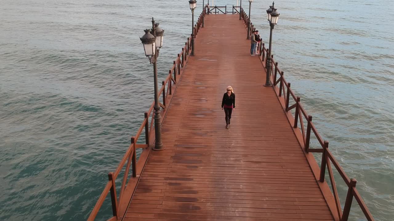 사람들이 걸어다니는 지중해의 목조 부두