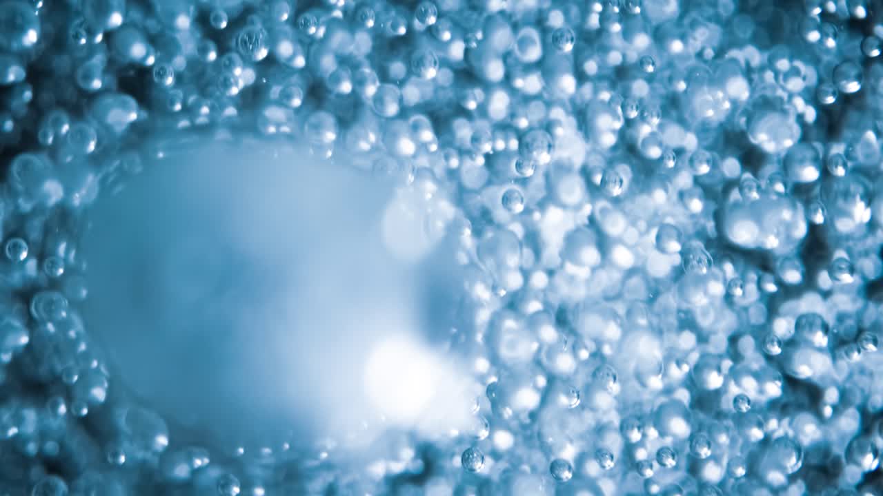 파란 물에 많은 물 거품이 가 ⁇ 게, 느린 움직임의 거품과 함께 추상적인 물 파동.