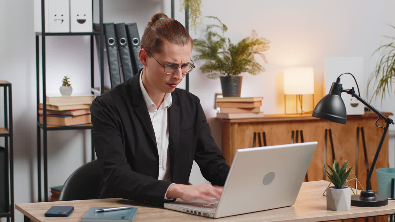 Un triste uomo d'affari che usa un portatile perde diventando sorpreso dai risultati improvvisi della lotteria alla scrivania dell'ufficio a casa