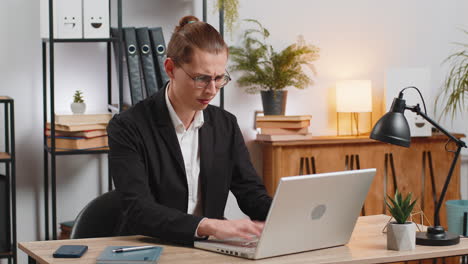 sad businessman using laptop loses becoming surprised sudden lottery results at home office desk