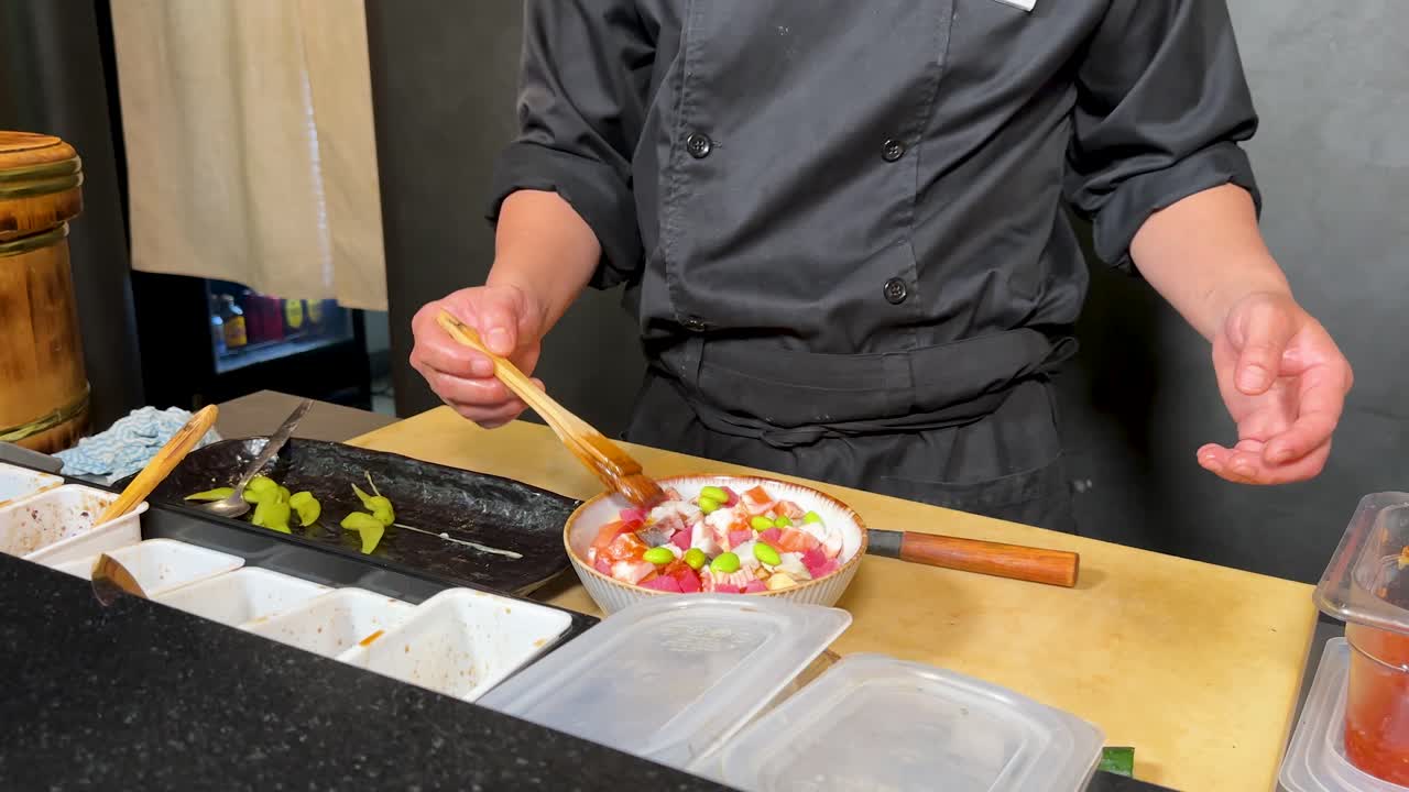 プロのシェフが、新鮮な食材を使ってカラフルなポケボウルを丁寧に盛り付けています。