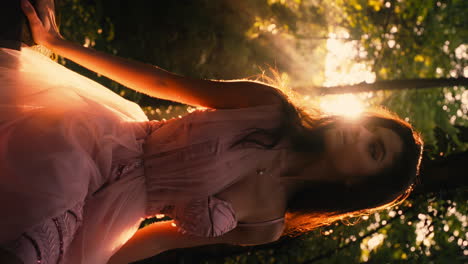 Beautiful-woman-wearing-pink-corset-floral-lace-dress-in-forest-sunlit-backdrop