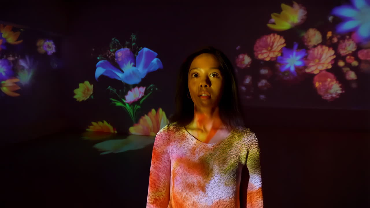 Woman Experiencing Vibrant Floral Light Projections in an Immersive Art Installation