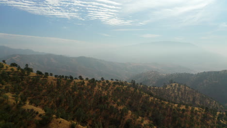 Smoky-haze-from-wildfires-fills-the-atmosphere-over-Southern-California's-Red-Mountain-range---panoramic-aerial-view