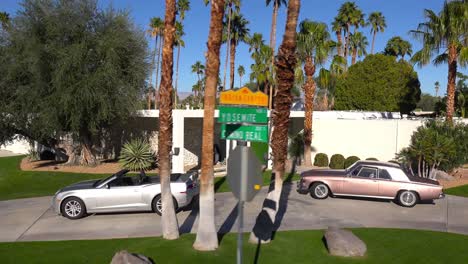 Traveling-shot-around-a-beautiful-Palm-Springs-California-mansion-with-luxury-cars-parked-outside