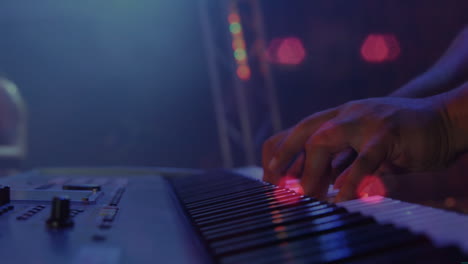 animación sobre el tráfico nocturno borroso sobre las manos de un hombre caucásico tocando el teclado en un concierto