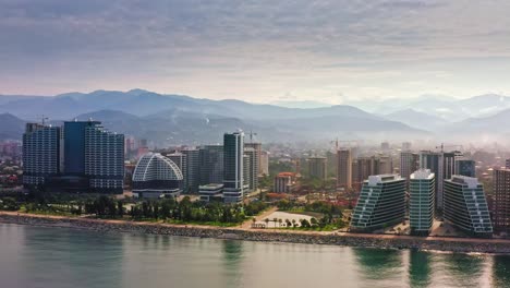 drone flight along the built up seashore of black sea against mountain landscape of adjara province, batumi, georgia