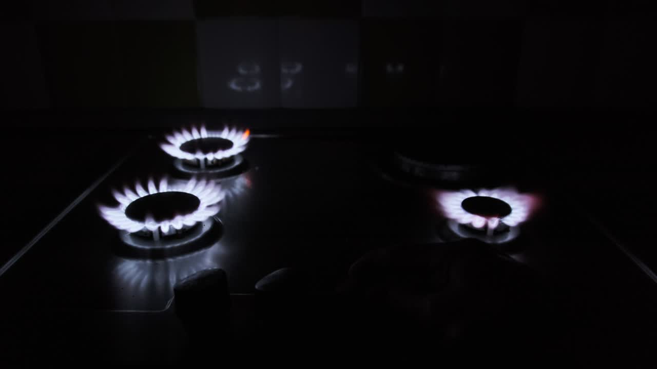 네 개의 가스 버너가 어 속에서 가스 스토브에서 동시에 불타고 있습니다.