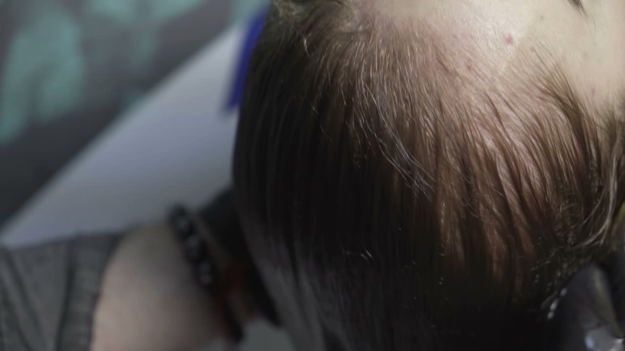 Young woman having her hair dyed by beautician at parlor