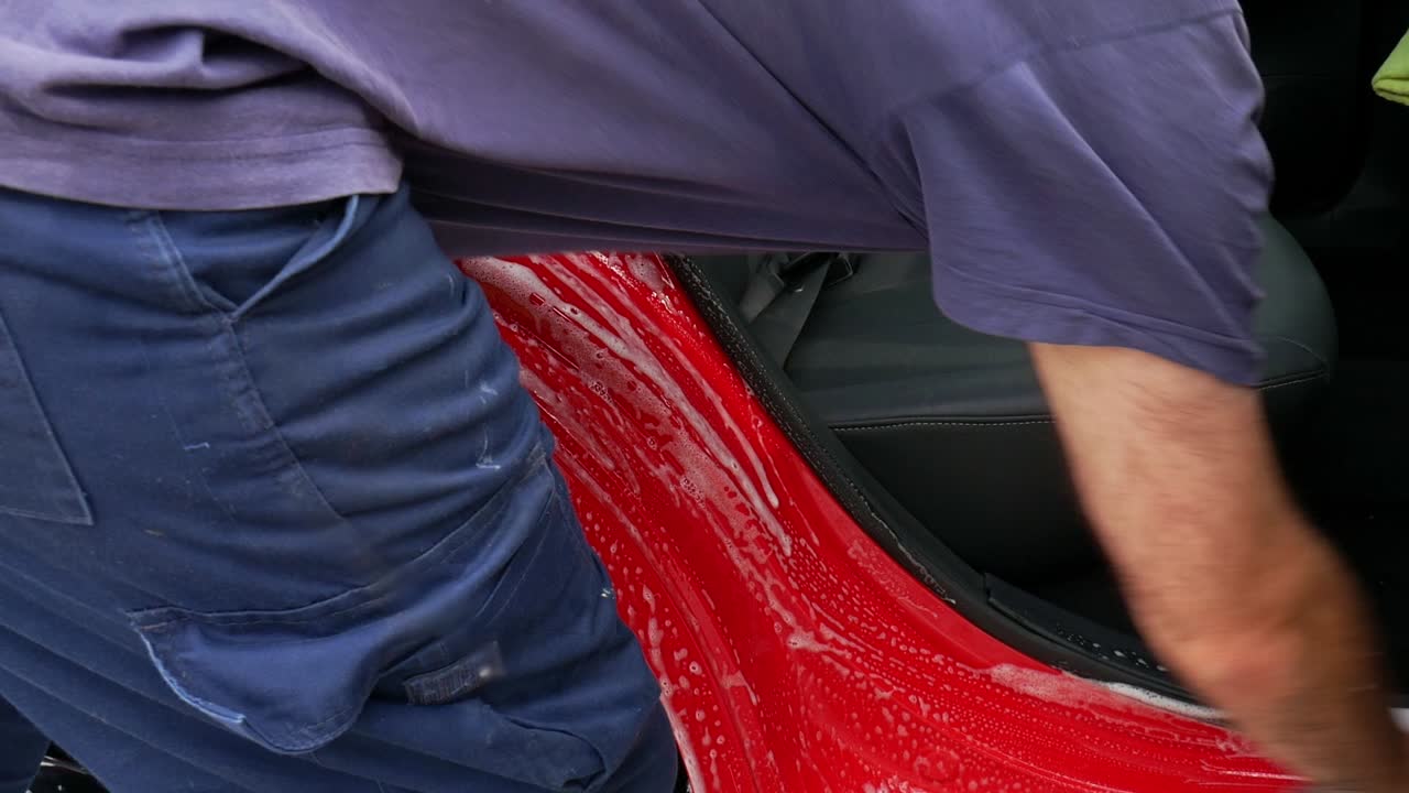 Cleaning rear door shut and sill with a microfiber wash mitt and lots of shampoo suds