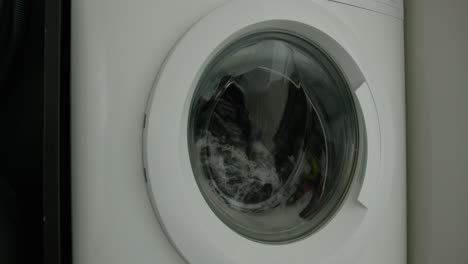 Close-Up-Pan-Right-of-a-Washing-Machine-Washing-Clothes