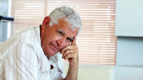 Depressed-senior-man-sitting-on-the-couch