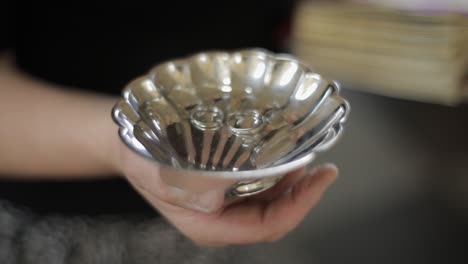 wedding silver rings lying on shiny church plate. shining with light. close-up