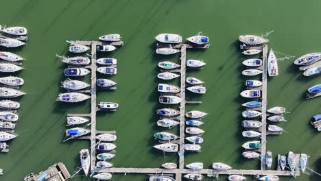 wide aerial shot flying over hamble river boatyard with many yachts and boats moored onto jetties